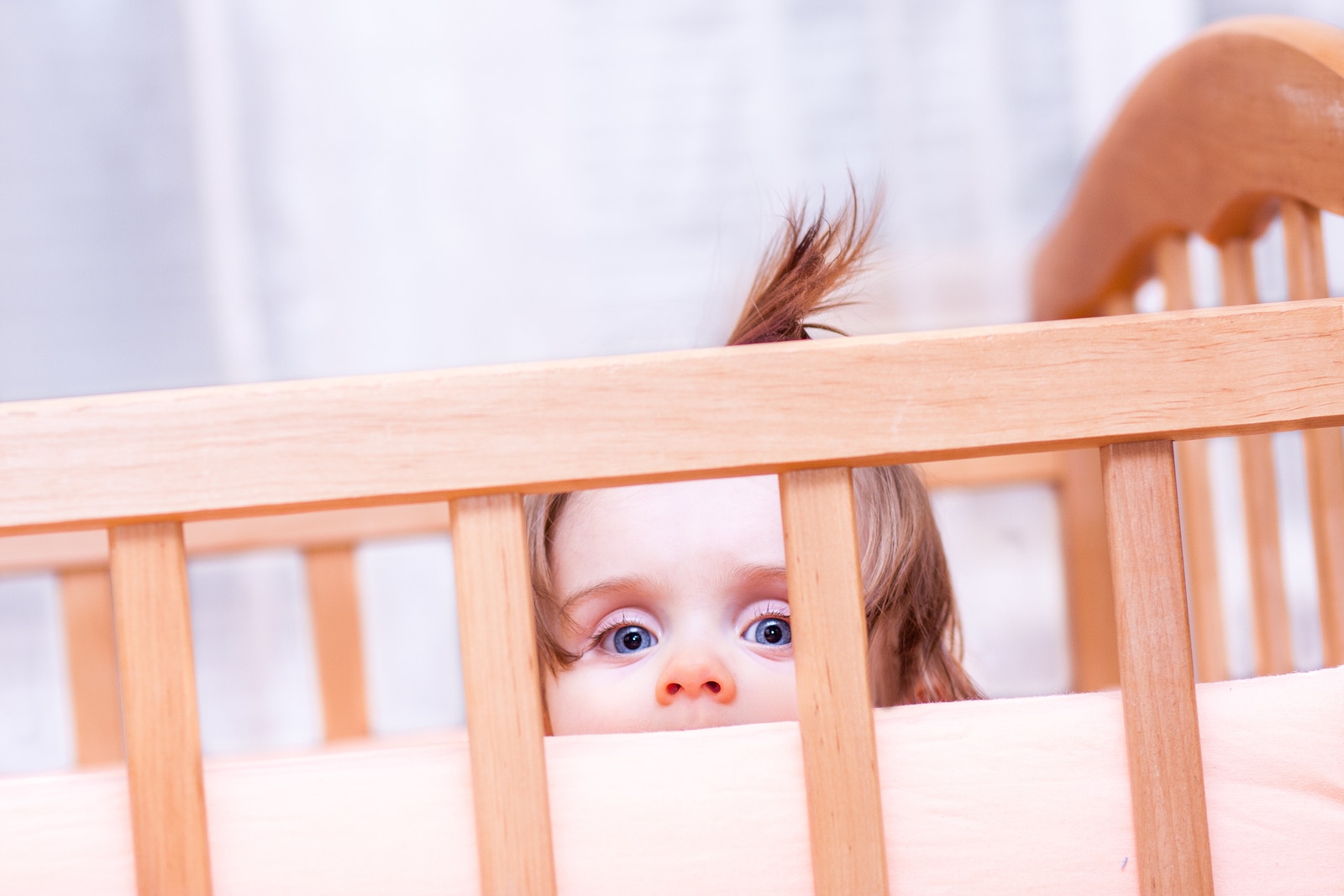 Little Girl Standing In The Crib