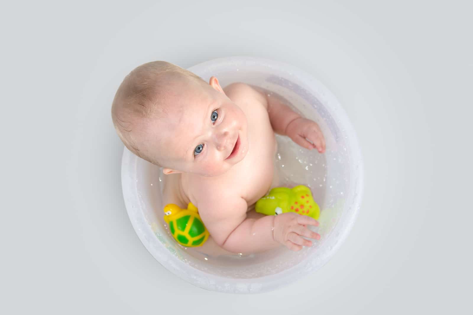 Cute Baby Having A Bath In Transparent Bucket And Playing With T